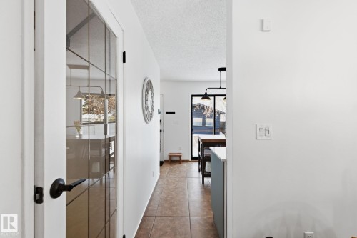 Hallway featuring dark tile patterned floors and a textured ceiling - 18717 57 Avenue, Edmonton, AB - Indoor Photo Showing Other Room