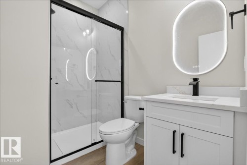 Bathroom featuring vanity, a marble finish shower, and wood finished floors - 10506 162 Street, Edmonton, AB - Indoor Photo Showing Bathroom