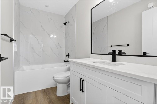 Bathroom featuring vanity,  shower combination, and dark wood finished floors - 10506 162 Street, Edmonton, AB - Indoor Photo Showing Bathroom