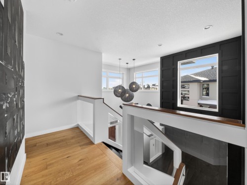 Bar featuring light wood finished floors, pendant lighting, and a textured ceiling - 5507 Chegwin Point(E), Edmonton, AB - Indoor Photo Showing Other Room