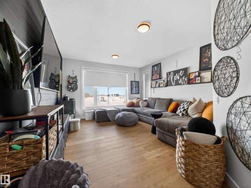 Living area with a textured ceiling and light wood finished floors - 5507 Chegwin Point(E), Edmonton, AB - Indoor Photo Showing Living Room