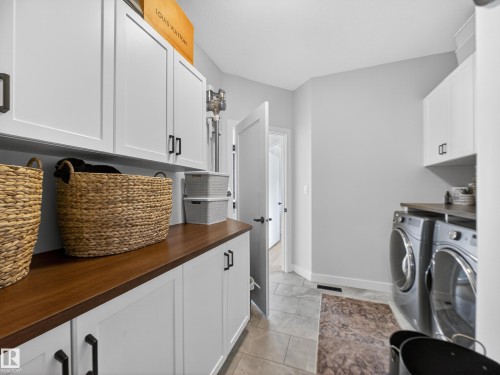 Laundry room featuring cabinet space and washer and clothes dryer - 5507 Chegwin Point(E), Edmonton, AB - Indoor Photo Showing Laundry Room