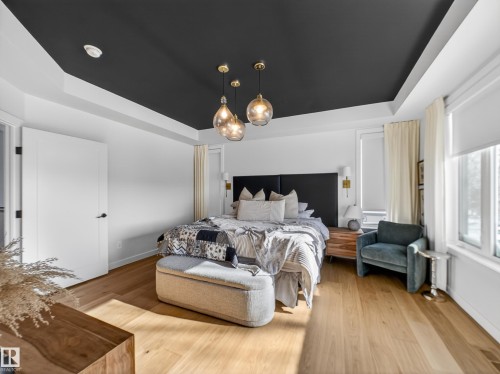 Bedroom featuring a tray ceiling and light wood-type flooring - 5507 Chegwin Point(E), Edmonton, AB - Indoor Photo Showing Bedroom