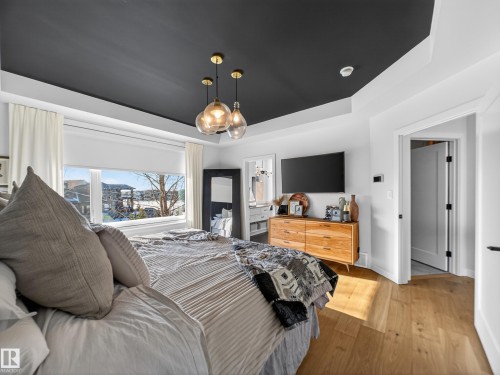 Bedroom with a raised ceiling and wood-type flooring - 5507 Chegwin Point(E), Edmonton, AB - Indoor Photo Showing Bedroom
