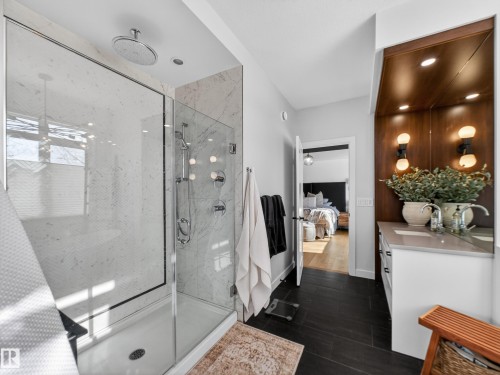 Full bath with vanity, connected bathroom, a marble finish shower, and dark wood-type flooring - 5507 Chegwin Point(E), Edmonton, AB - Indoor Photo Showing Bathroom