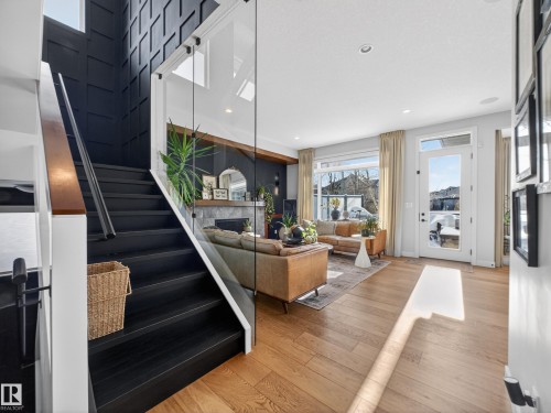 Staircase with healthy amount of natural light, a fireplace, hardwood / wood-style floors, and recessed lighting - 5507 Chegwin Point(E), Edmonton, AB - Indoor