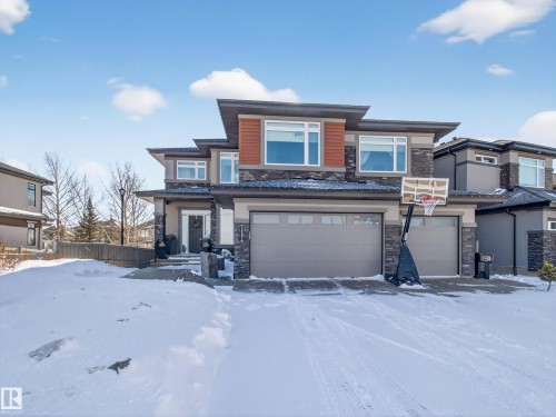 Prairie-style house featuring stone siding, a garage, and stucco siding - 5507 Chegwin Point(E), Edmonton, AB - Outdoor With Facade