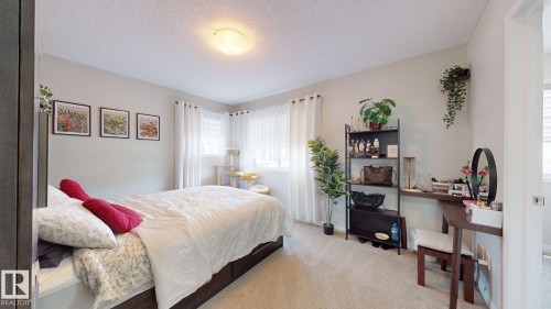 Carpeted bedroom featuring a textured ceiling - 1275 Chappelle Boulevard Sw, Edmonton, AB - Indoor Photo Showing Bedroom