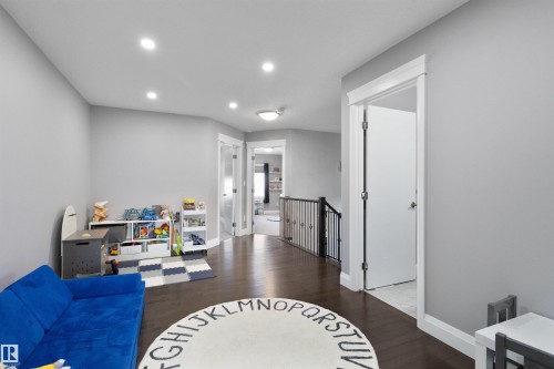 Living area with dark wood finished floors, recessed lighting, and an upstairs landing - 56 Durrand Bend, Fort Saskatchewan, AB - Indoor
