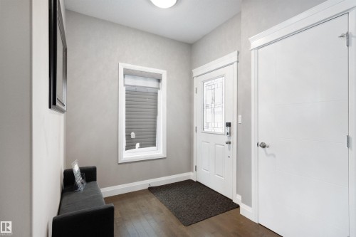 Foyer entrance with dark wood finished floors and baseboards - 56 Durrand Bend, Fort Saskatchewan, AB - Indoor Photo Showing Other Room