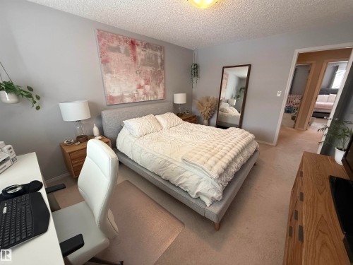 Bedroom featuring carpet flooring, a textured ceiling, an office area, and a closet - 19 2021 Grantham Crest, Edmonton, AB - Indoor Photo Showing Bedroom