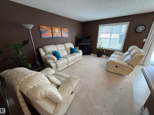 Carpeted living area featuring a textured ceiling and baseboards - 19 2021 Grantham Crest, Edmonton, AB - Indoor Photo Showing Living Room