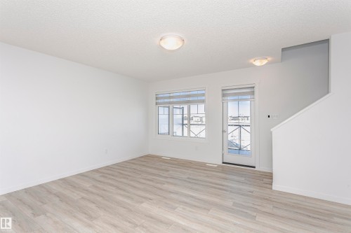 Empty room with light wood-style floors and a textured ceiling - 2412 192 Street, Edmonton, AB - Indoor Photo Showing Other Room