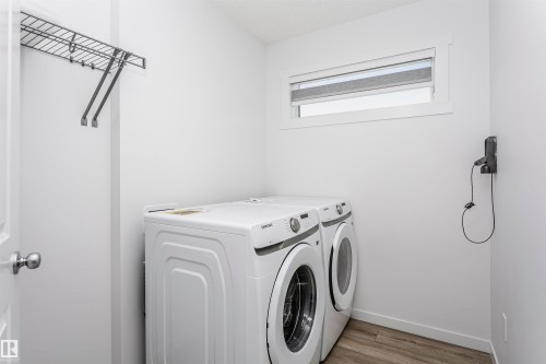 Laundry area featuring wood finished floors and washer and clothes dryer - 2412 192 Street, Edmonton, AB - Indoor Photo Showing Laundry Room