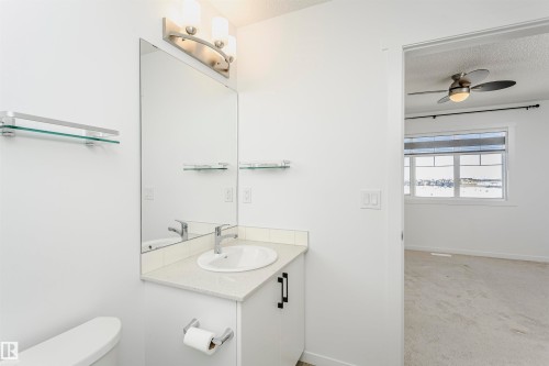 Bathroom featuring vanity, a textured ceiling, light colored carpet, and a ceiling fan - 2412 192 Street, Edmonton, AB - Indoor Photo Showing Bathroom