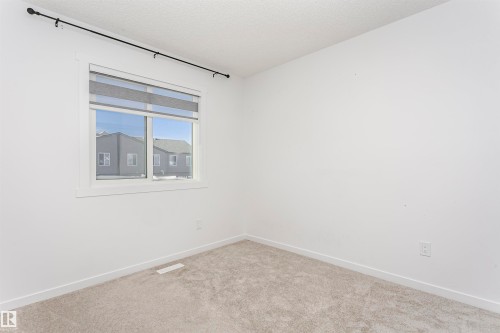 Carpeted empty room featuring baseboards and a textured ceiling - 2412 192 Street, Edmonton, AB - Indoor Photo Showing Other Room