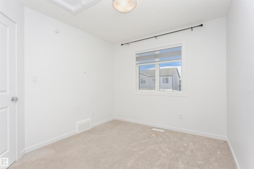 Unfurnished room with a textured ceiling and light carpet - 2412 192 Street, Edmonton, AB - Indoor Photo Showing Other Room