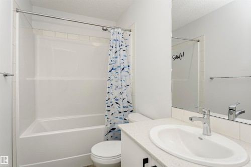 Bathroom with vanity, a textured ceiling, and shower / bath combo with shower curtain - 2412 192 Street, Edmonton, AB - Indoor Photo Showing Bathroom