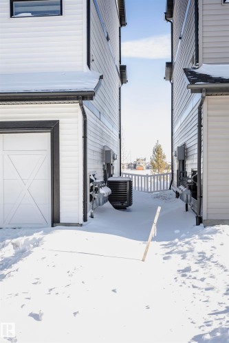 View of snow covered exterior featuring a garage and a central air condition unit - 2412 192 Street, Edmonton, AB - Outdoor With Exterior