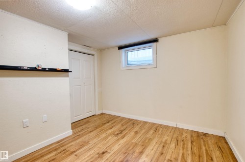 Basement with light wood-type flooring and a textured ceiling - 9907 165 Street, Edmonton, AB - Indoor Photo Showing Other Room