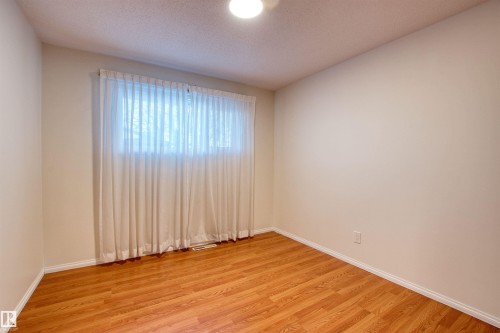 Spare room with light wood-style flooring and a textured ceiling - 9907 165 Street, Edmonton, AB - Indoor Photo Showing Other Room