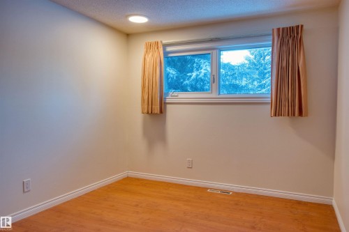 Unfurnished room featuring wood finished floors and a textured ceiling - 9907 165 Street, Edmonton, AB - Indoor Photo Showing Other Room