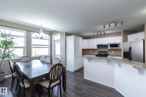 Dining space with suspended lighting, dark wood-type flooring, and a textured ceiling - 16454 61A Street, Edmonton, AB - Indoor