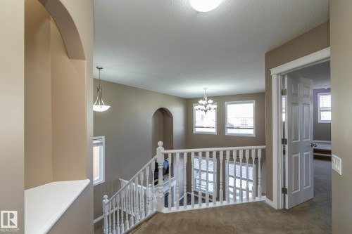 Hallway with arched walkways, an upstairs landing, carpet, and a chandelier - 16454 61A Street, Edmonton, AB - Indoor Photo Showing Other Room
