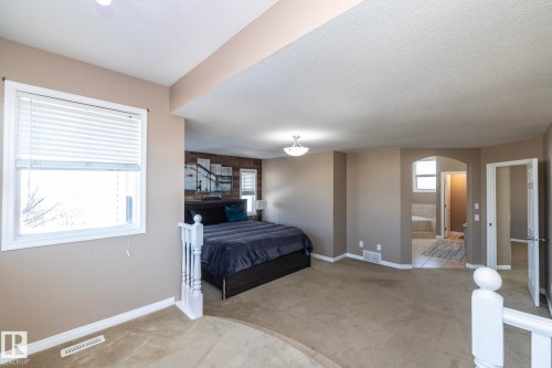 Bedroom with carpet floors, arched walkways, and connected bathroom - 16454 61A Street, Edmonton, AB - Indoor Photo Showing Bedroom