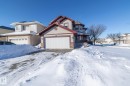 View of front of home featuring a garage, a residential view, and stone siding - 16454 61A Street, Edmonton, AB  - Outdoor With Facade 