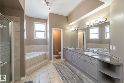 Full bath with a garden tub, double vanity, light tile patterned floors, and a shower stall - 16454 61A Street, Edmonton, AB - Indoor Photo Showing Bathroom