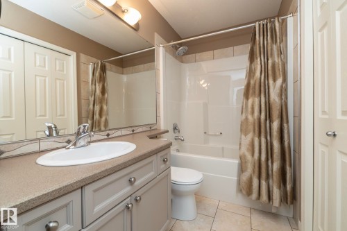 Bathroom with vanity, shower / bath combination with curtain, and light tile patterned flooring - 16454 61A Street, Edmonton, AB - Indoor Photo Showing Bathroom