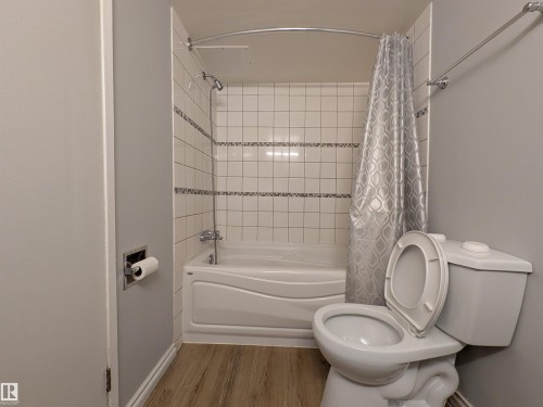 Full bath with shower / bath combination with curtain and light wood-style flooring - 109 7220 144 Avenue, Edmonton, AB - Indoor Photo Showing Bathroom