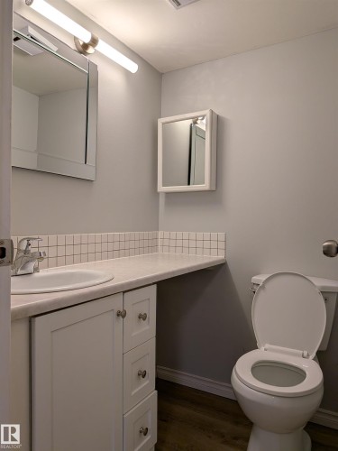 Bathroom featuring vanity and dark wood-style flooring - 109 7220 144 Avenue, Edmonton, AB - Indoor Photo Showing Bathroom