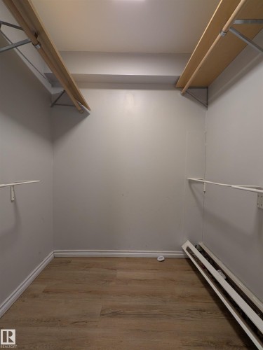 Walk in closet with a baseboard heating unit and light wood-type flooring - 109 7220 144 Avenue, Edmonton, AB - Indoor With Storage