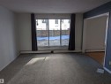 Carpeted spare room with a textured ceiling and a baseboard radiator - 109 7220 144 Avenue, Edmonton, AB  - Indoor Photo Showing Other Room 