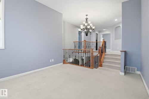 Empty room with arched walkways, carpet, and suspended lighting - 12634 16A Avenue, Edmonton, AB - Indoor Photo Showing Other Room