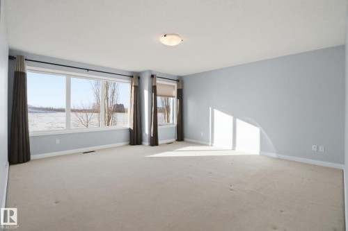 Spare room featuring baseboards and light carpet - 12634 16A Avenue, Edmonton, AB - Indoor Photo Showing Other Room