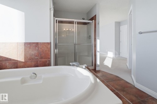 Full bath featuring a garden tub, a stall shower, and dark tile patterned flooring - 12634 16A Avenue, Edmonton, AB - Indoor Photo Showing Bathroom