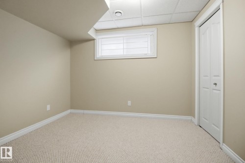 Unfurnished bedroom with a drop ceiling, a closet, and carpet flooring - 12634 16A Avenue, Edmonton, AB - Indoor Photo Showing Other Room