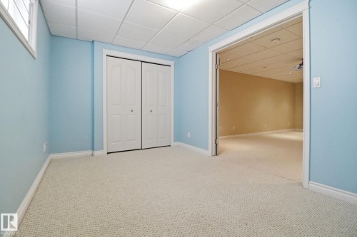 Unfurnished bedroom with a drop ceiling, carpet flooring, and a closet - 12634 16A Avenue, Edmonton, AB - Indoor Photo Showing Other Room
