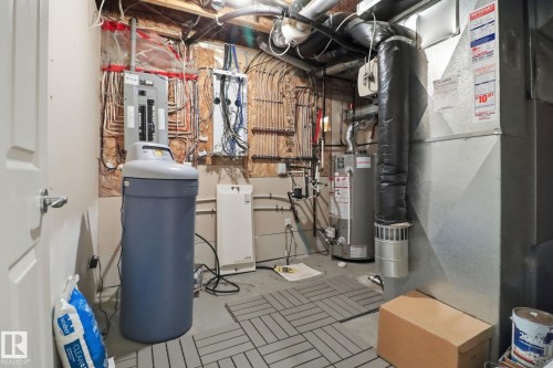 Utility room featuring water heater, heating unit, and electric panel - 12634 16A Avenue, Edmonton, AB - Indoor Photo Showing Basement