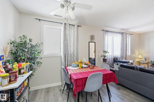Dining area with a textured ceiling, light wood-style flooring, and a ceiling fan - 1482 Lakewood Road W, Edmonton, AB - Indoor
