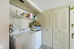 Laundry area with washer and dryer, light wood-type flooring, and a textured ceiling - 