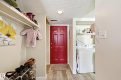Laundry area featuring a textured ceiling, independent washer and dryer, and light wood-type flooring - 