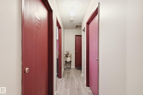 Corridor with light wood-style floors and a textured ceiling - 1482 Lakewood Road W, Edmonton, AB - Indoor