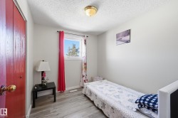 Bedroom featuring light wood-type flooring, a textured ceiling, and a closet - 