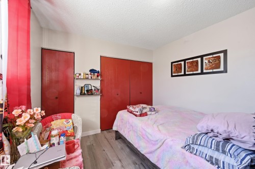 Bedroom with a textured ceiling, dark wood-type flooring, and a closet - 1482 Lakewood Road W, Edmonton, AB - Indoor Photo Showing Bedroom