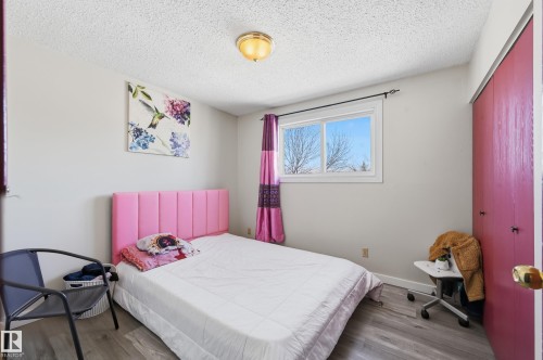 Bedroom with wood finished floors, a textured ceiling, and a closet - 1482 Lakewood Road W, Edmonton, AB - Indoor Photo Showing Bedroom
