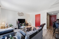 Living room with light wood-type flooring and a textured ceiling - 